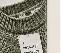 Green sweater with A BRIGHTER TOMORROW tag